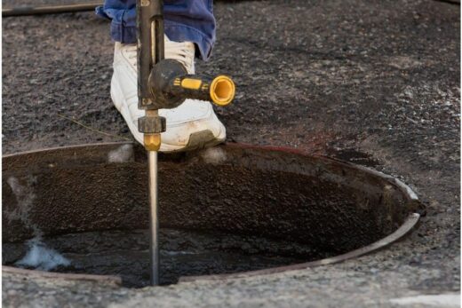 Curage haute pression d'une canalisation depuis une chambre de visite