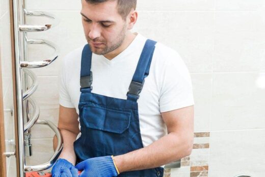 Plombier réparant une conduite dans une salle de bain