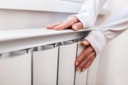 hoogvermogen radiator centrale verwarming vrouw warmt handen huishoudelijk centraal verwarmingssysteem